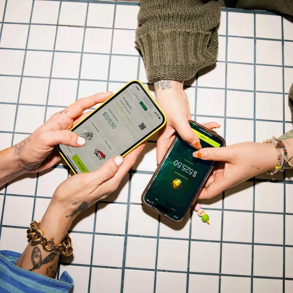 Dos amigos juntando sus celulares para mandarse dinero